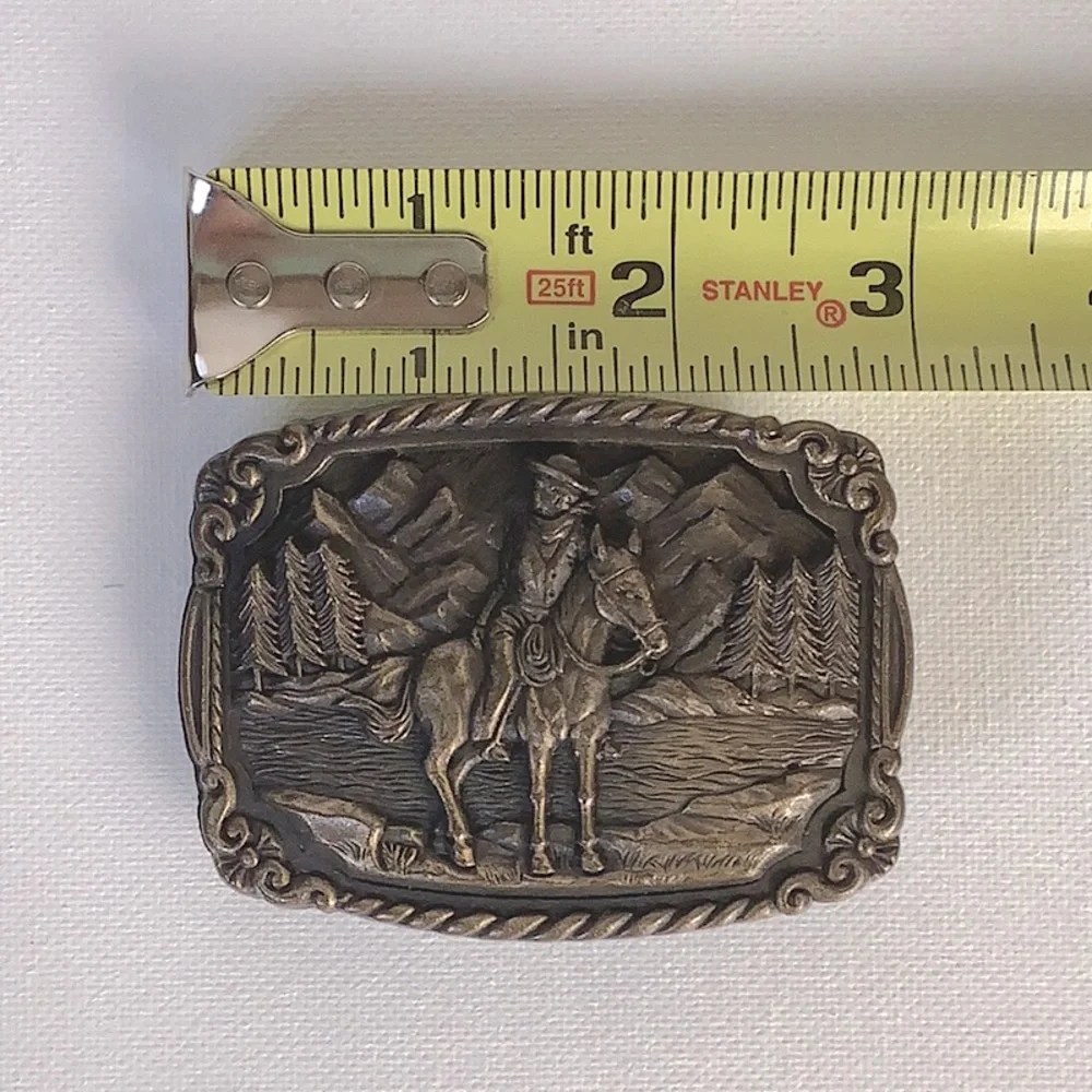 Vintage 1970’s belt buckle with cowboy on a horse with trees & mountains